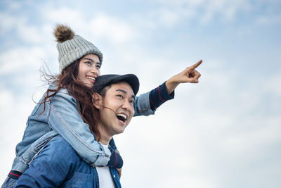 Portrait of smiling young woman against sky