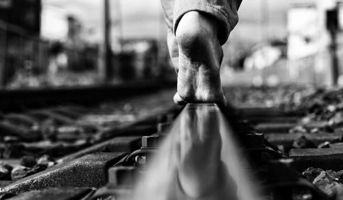 Low section of man walking on railroad tracks