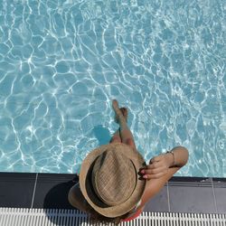 High angle view of woman sitting by swimming pool