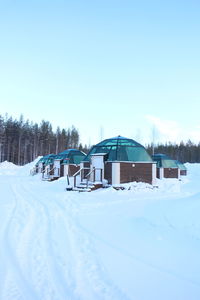 Snow covered field against clear sky