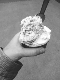 Cropped hand holding cup with ice cream