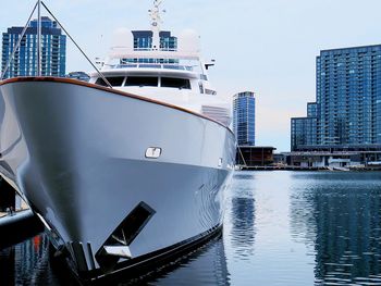 Ship moored in sea against buildings in city