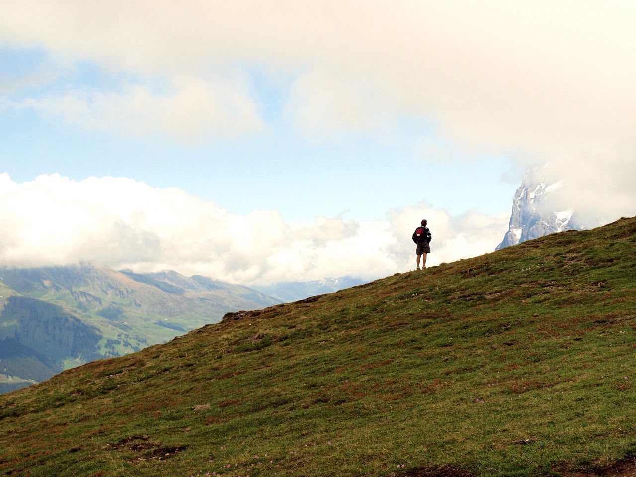 mountain, full length, leisure activity, lifestyles, sky, men, landscape, tranquil scene, tranquility, standing, rear view, scenics, mountain range, grass, nature, hiking, cloud - sky, beauty in nature