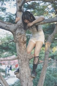 Full length of woman on tree trunk