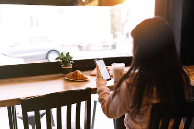 Woman holding coffee cup on table at home