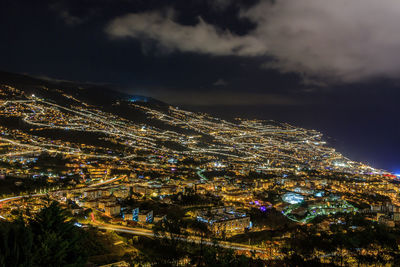 High angle view of illuminated buildings against sky at night