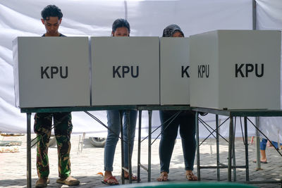 People standing by boxes with text