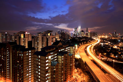 Illuminated cityscape against sky at night