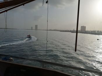 Person sailing in sea against sky