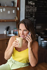 Young woman drinking coffee at restaurant