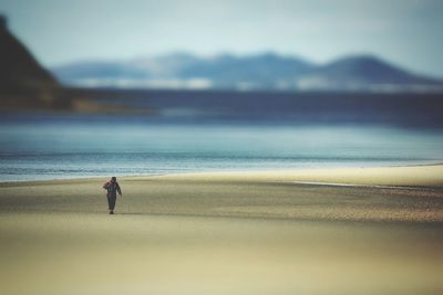 Rear view of man walking on beach