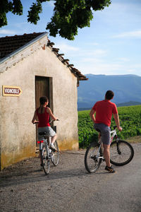 Rear view of people riding bicycle