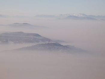 Scenic view of foggy landscape against sky