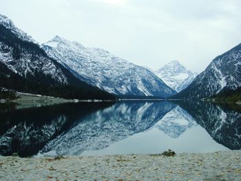 Scenic view of lake and snowcapped mountains against sky