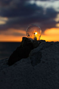 Close-up of illuminated rock against sky during sunset