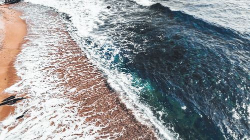 High angle view of surf on stormy beach