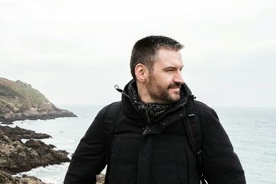 Man looking away against sea