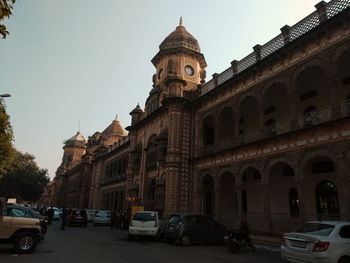 Cars on street amidst buildings against sky in city