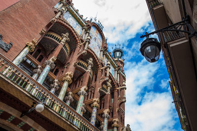 Low angle view of buildings against cloudy sky