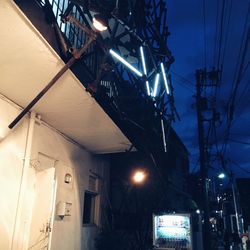 Low angle view of illuminated lamp at night