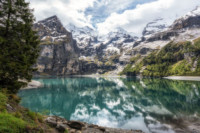 The view of oeschinenee lake and oeschinen valley amongst bernese alps mountain tops. 