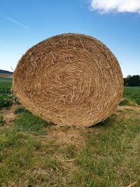 Hay bales on field against sky