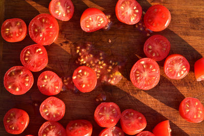 Above view of grape tomatoes cut into halves on wood cutting board