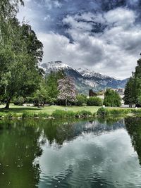 Scenic view of lake by trees against sky