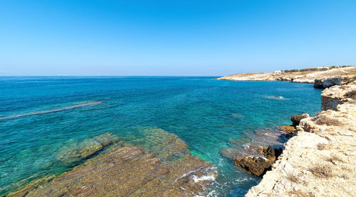 Scenic view of sea against clear blue sky