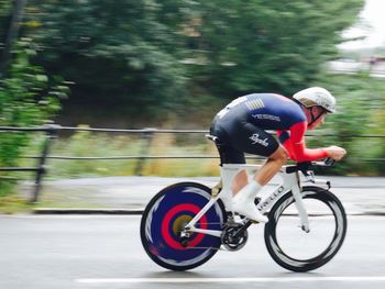 Blurred motion of people riding bicycle on road