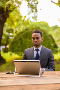 Young man using mobile phone on table