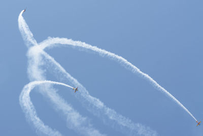 Low angle view of airshow against blue sky