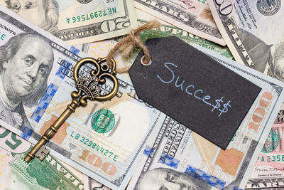 High angle view of key ring on paper currency