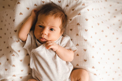 High angle view of cute baby boy sleeping on bed at home