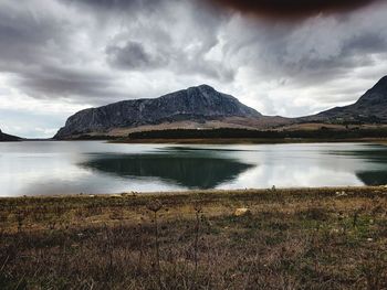 Scenic view of lake by mountains against sky