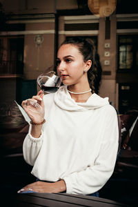 Young woman holding ice cream in restaurant