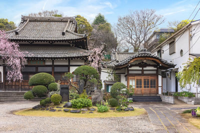 Traditional building by trees against sky