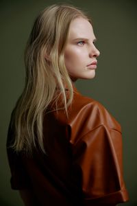 Portrait of young woman against wall