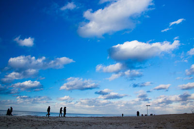 People on beach against sky
