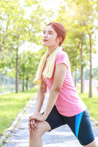 Young woman exercising on footpath at park