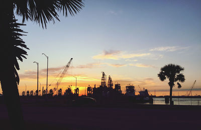 Silhouette palm trees against sky during sunset