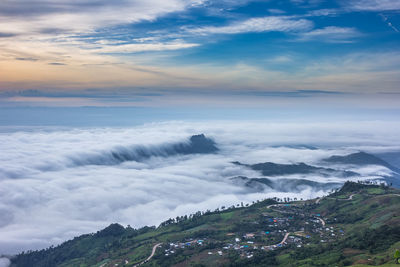 Scenic view of mountains against cloudy sky during sunset