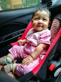 Portrait of cute baby girl sitting in car