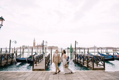 Rear view of people on pier against sky