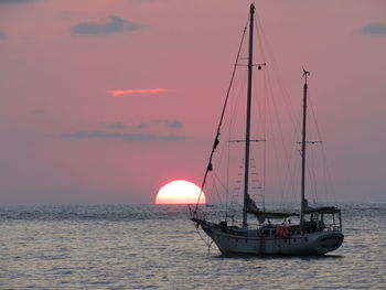 Sailboat sailing on sea against sky during sunset