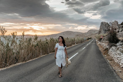Portrait of woman on road against sky