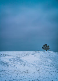 Scenic view of snow covered field against sky