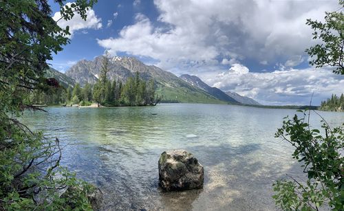 Scenic view of lake by trees against sky