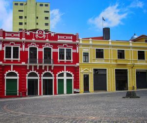 Building by street against sky in city