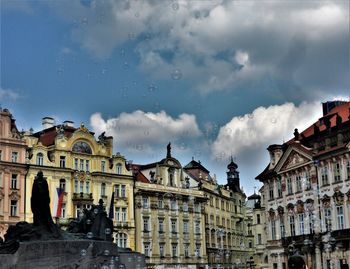 Low angle view of buildings against cloudy sky